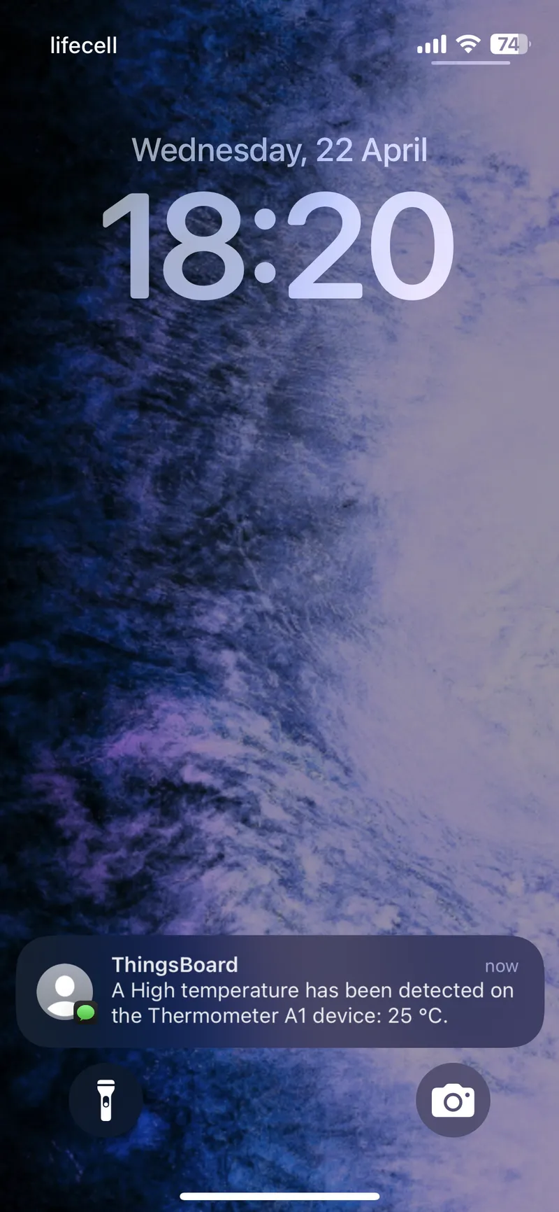 iPhone lock screen showing SMS notification about high temperature alarm